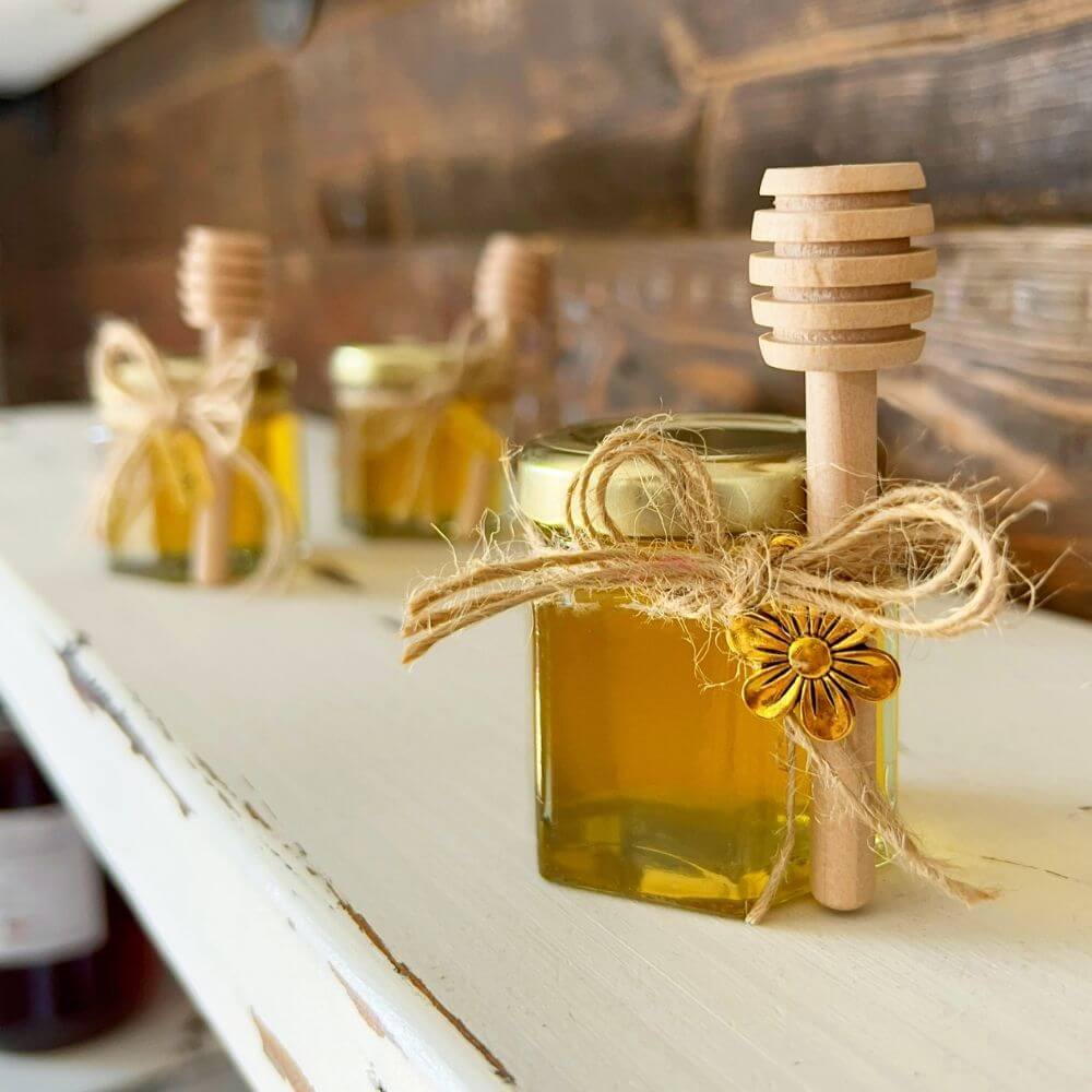 Filled Hexagon Honey Wedding Favor with Flower Charm and Honey Dipper on Shelf